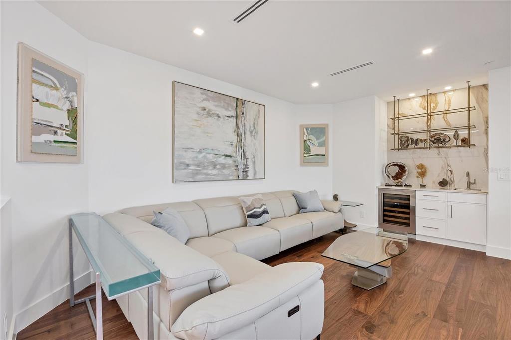 A living room features a light-colored sectional sofa, a glass coffee table, and a wet bar — 1211 GULF OF MEXICO DRIVE UNIT 1005, LONGBOAT KEY, FL