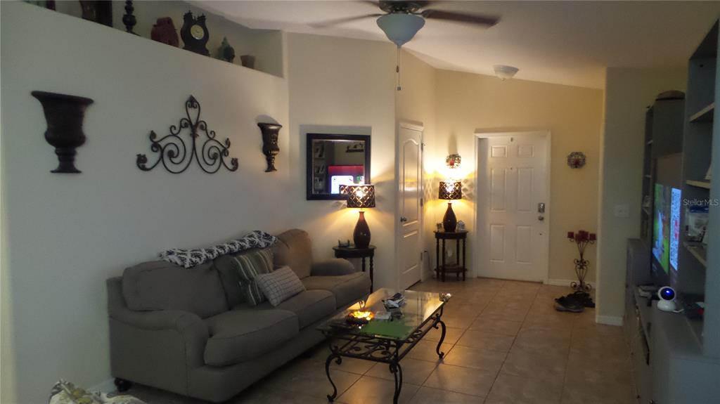 A living room features a gray sofa, a glass coffee table, and tile flooring — 2350 RICHWOOD PIKE DRIVE, RUSKIN, FL