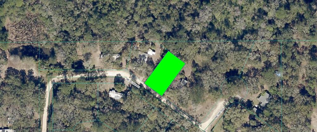 An aerial view shows a rectangular plot of land highlighted in green within a wooded area — NE 6TH LANE ROAD, SILVER SPRINGS, FL