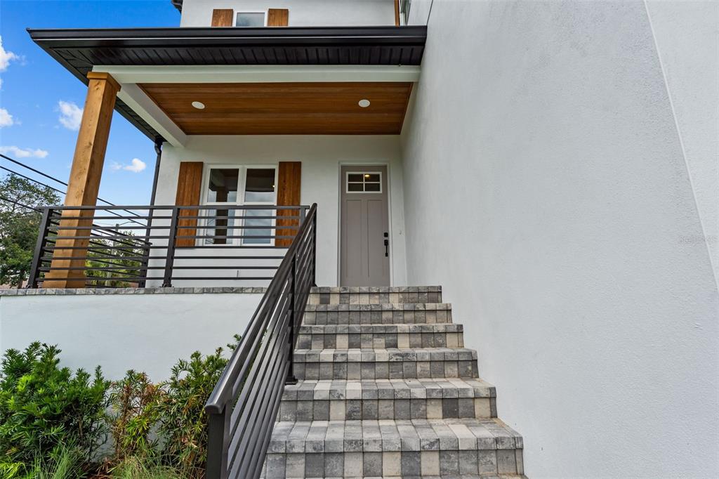 A set of stone steps leads to a covered porch with a gray front door — 7402 S SWOOPE STREET, TAMPA, FL