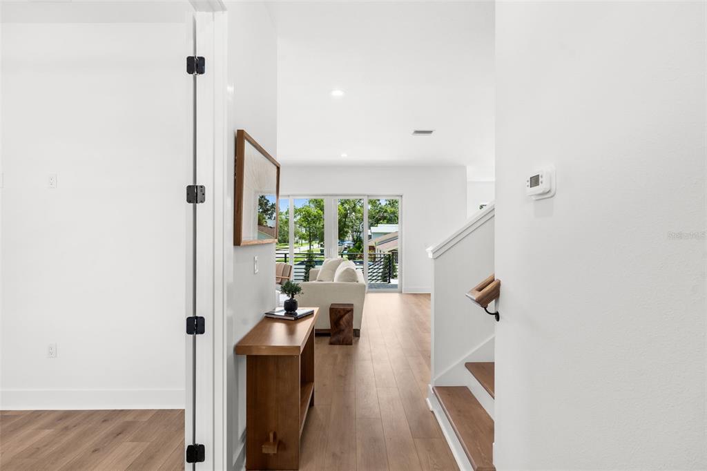 A view from a doorway looking into a living room with wood floors and stairs — 7402 S SWOOPE STREET, TAMPA, FL