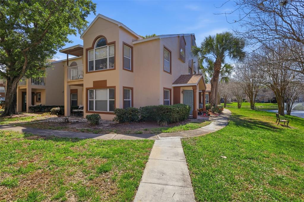 A two-story tan apartment building with brown trim, a balcony, and a sidewalk exterior — 5452 E MICHIGAN STREET UNIT 5452-7, ORLANDO, FL