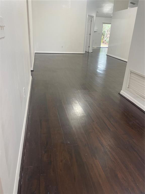 An interior view of a room with dark wood flooring and white walls — 5418 FREDERICK LAKE DRIVE, PORT ORANGE, FL
