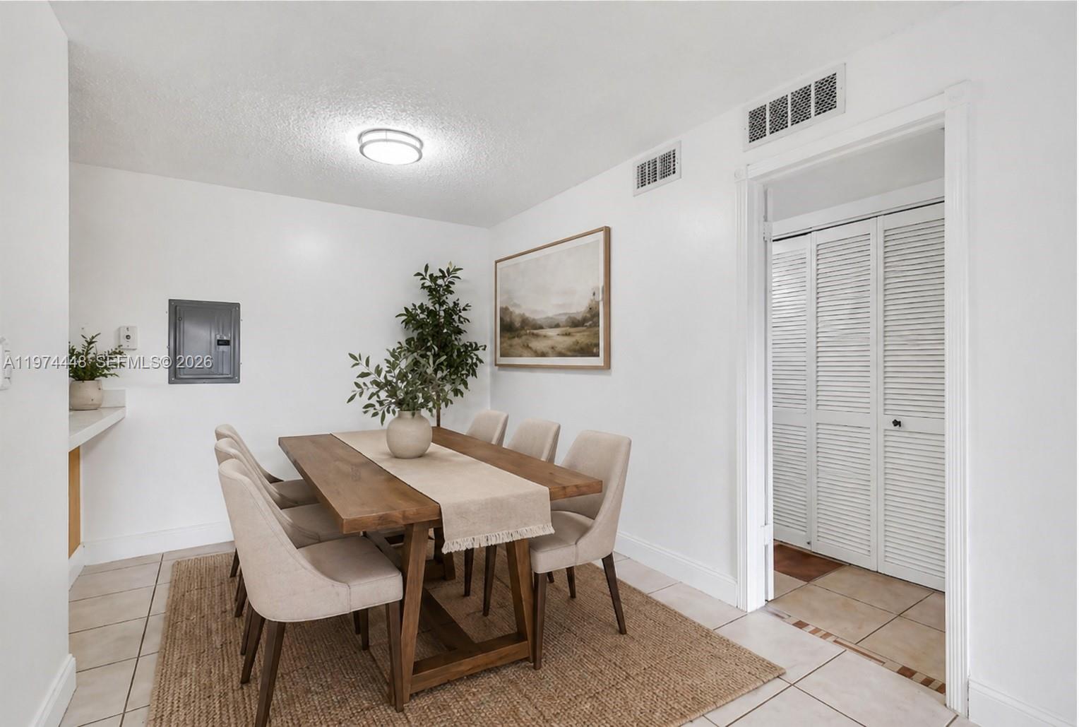 A dining room features a wooden table with six chairs on a jute rug — 13787 SW 66th St # 254D, Miami FL 33183, MIAMI, FL