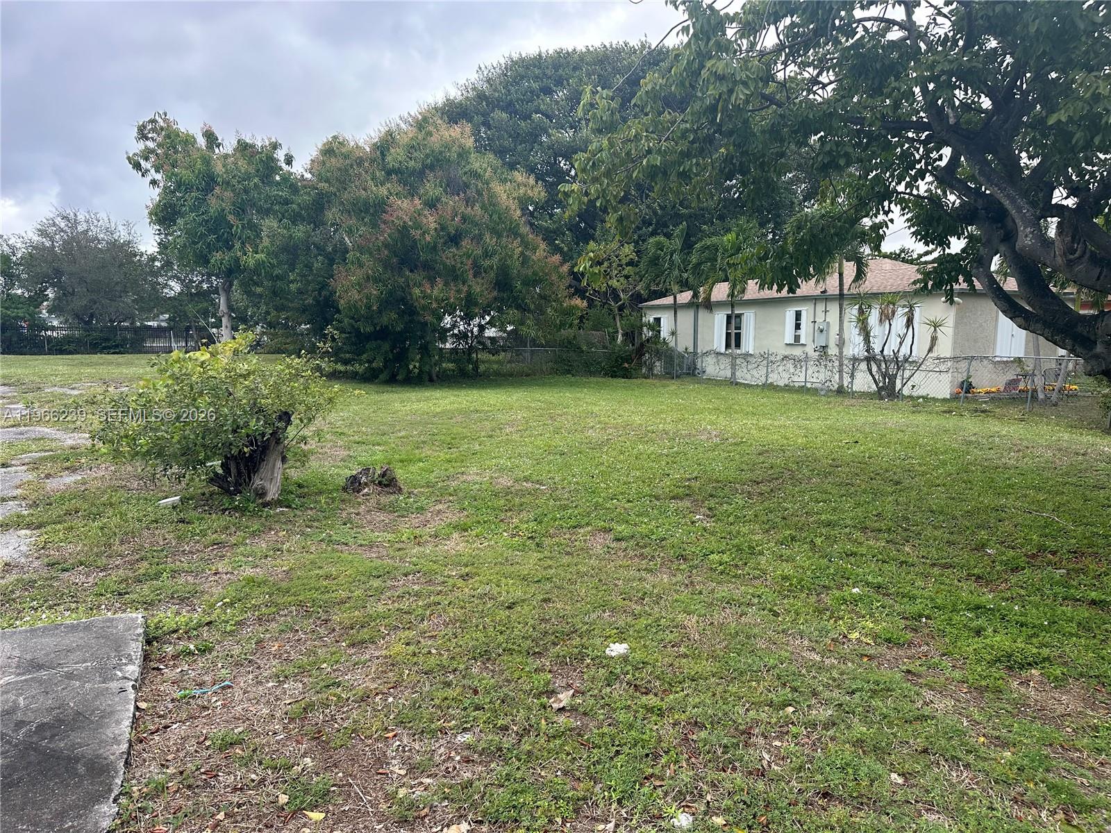 A grassy lot features a small shrub in the foreground and a house nearby — . NW 2nd Ave, Hallandale Beach FL 33009, HALLANDALE BEACH, FL