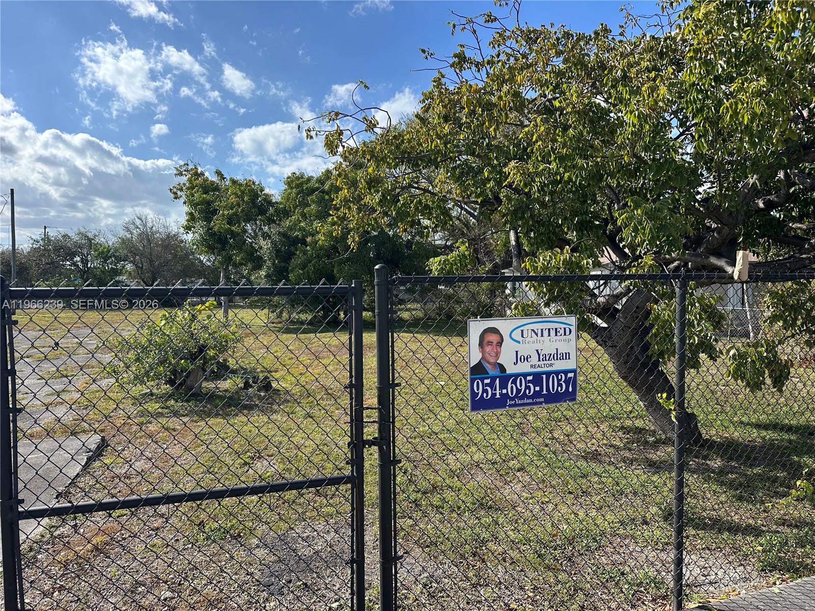 A chain-link fence encloses a vacant lot with trees and a real estate sign — . NW 2nd Ave, Hallandale Beach FL 33009, HALLANDALE BEACH, FL