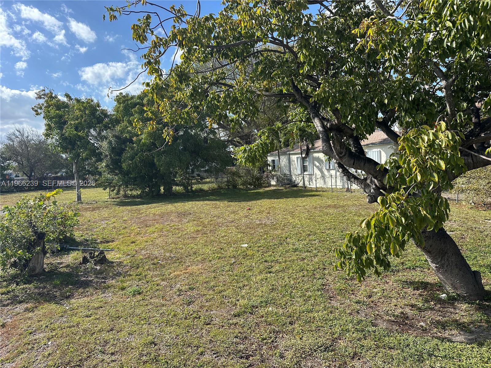 A large, grassy yard features several mature trees and a single-story house in the background — . NW 2nd Ave, Hallandale Beach FL 33009, HALLANDALE BEACH, FL