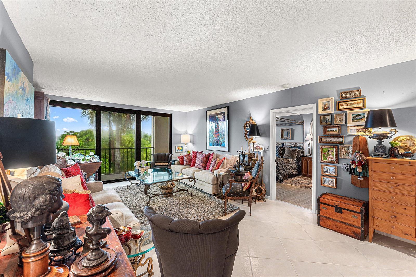 A living room features light gray walls, a beige sofa, tile flooring, and a balcony view — 5951 Wellesley Park Drive # 507, Boca Raton FL 33433, BOCA RATON, FL