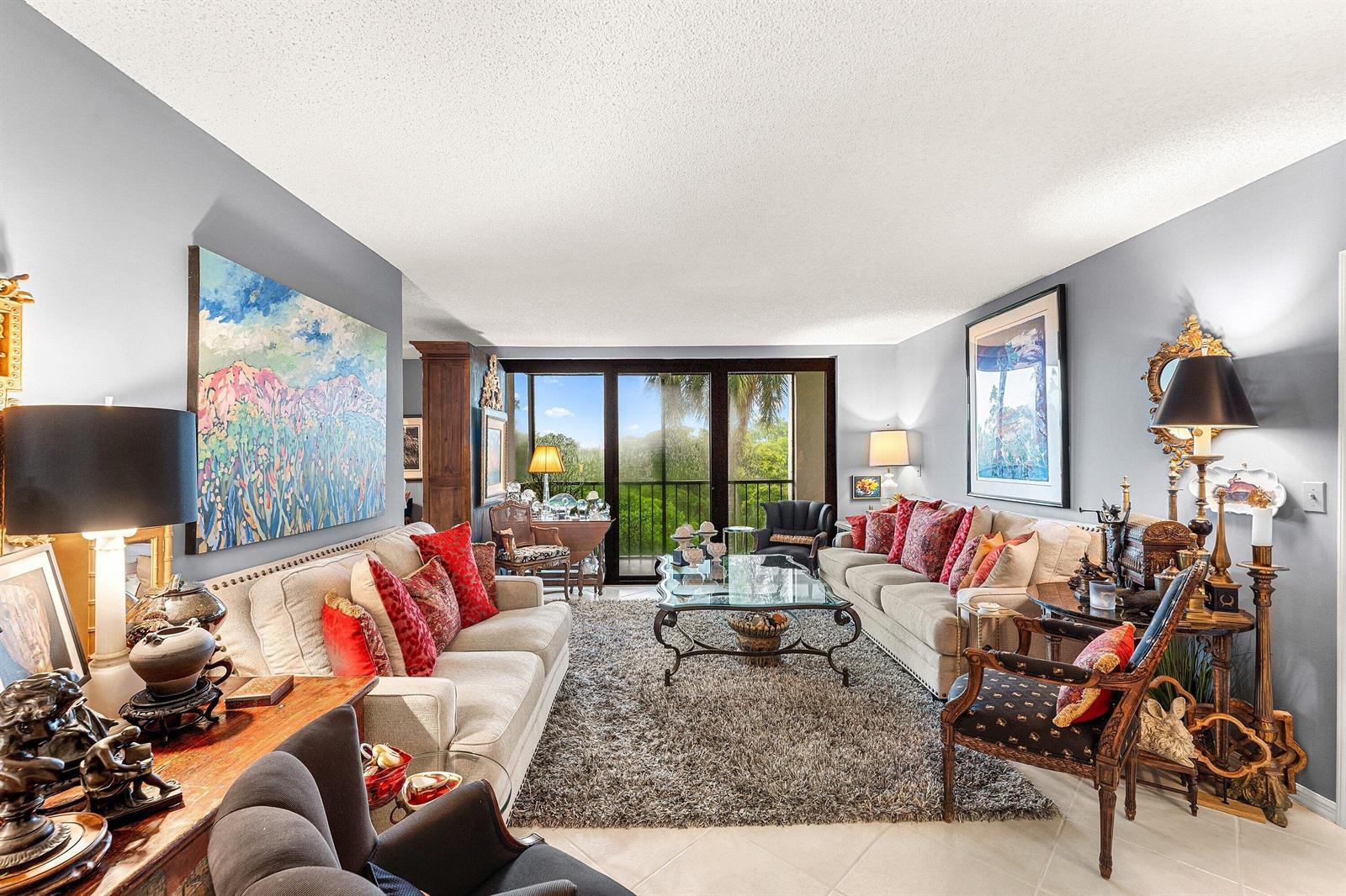 A living room features two beige sofas, a glass coffee table, and a balcony view — 5951 Wellesley Park Drive # 507, Boca Raton FL 33433, BOCA RATON, FL