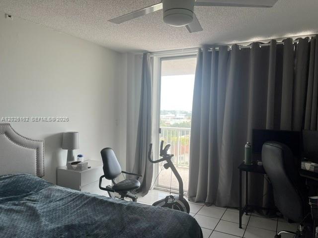 A bedroom features a bed, a stationary bike, a desk, and a sliding glass door — 1800 NW 24th Ave # 705, Miami FL 33125, MIAMI, FL