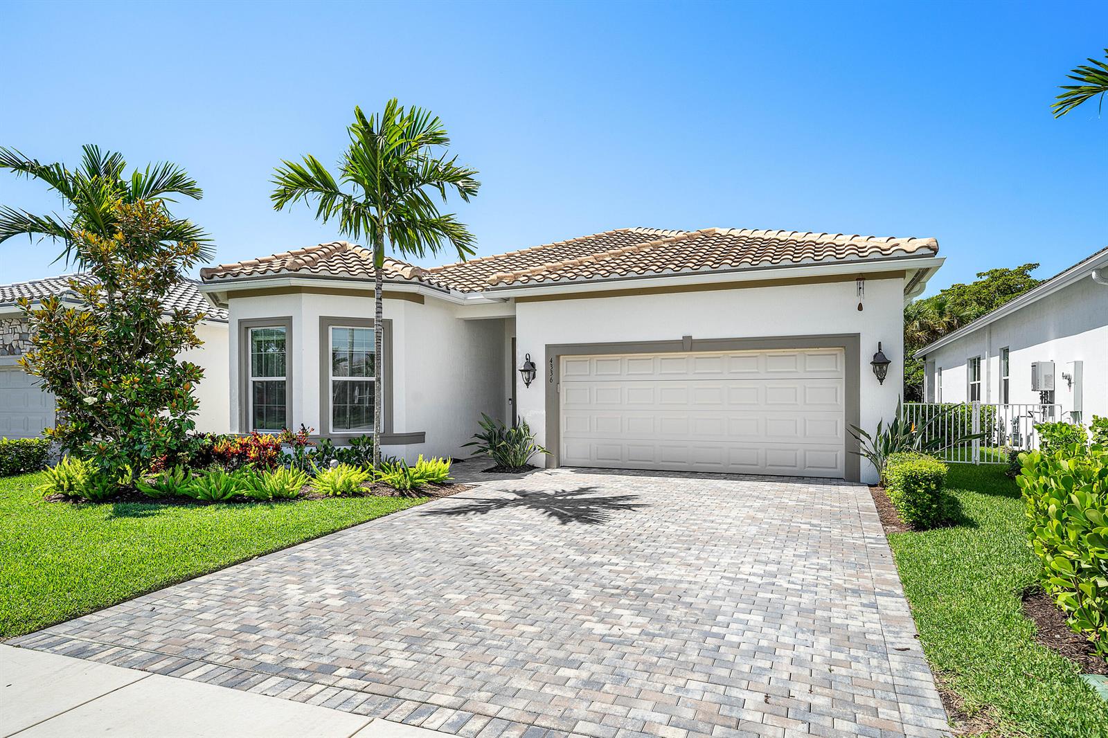 A single-story house with a paved driveway, a two-car garage, and palm trees — 4336 Matilda Court, Delray Beach FL 33445, DELRAY BEACH, FL