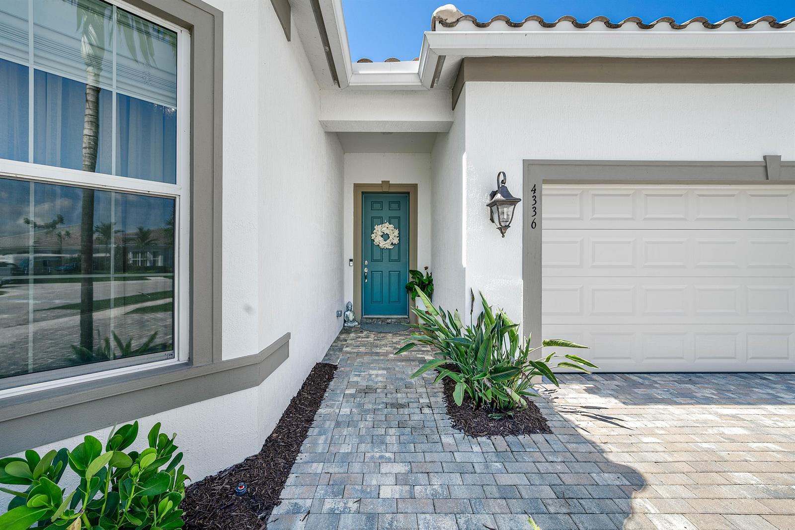 The exterior view shows a white stucco house with a teal front door and garage — 4336 Matilda Court, Delray Beach FL 33445, DELRAY BEACH, FL