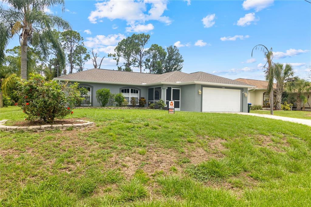 A single-story house with a gray exterior, a two-car garage, and a front lawn — 2745 NELLIE LANE, NORTH PORT, FL