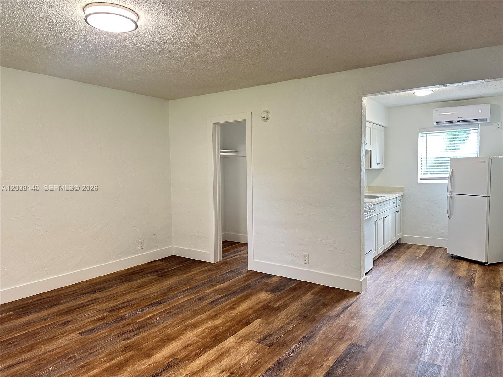 A kitchen features white cabinets, a white stove, a refrigerator, and wood-look flooring — 1821 Thomas St # 2, Hollywood FL 33020, HOLLYWOOD, FL