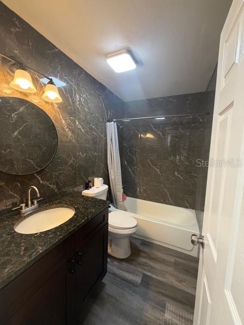 A bathroom features dark marble-patterned walls, a vanity with a dark cabinet, and a tub — 9009 TUDOR DRIVE UNIT G106, TAMPA, FL