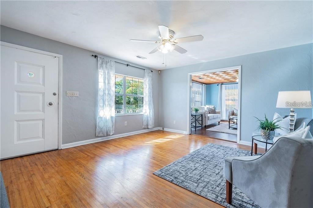A living room with hardwood floors, a ceiling fan, and an entryway to another room — 5418 RIVERHILLS DRIVE, TEMPLE TERRACE, FL