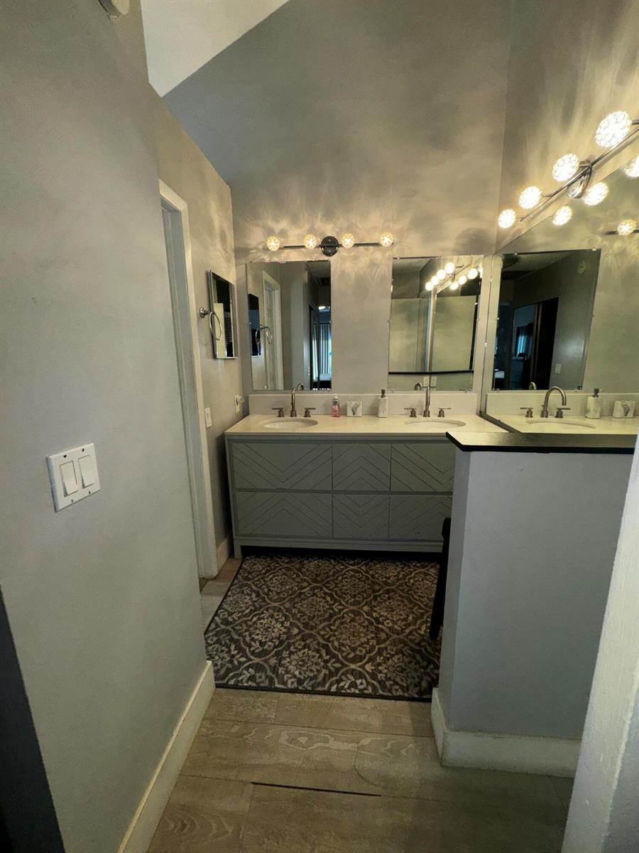 A bathroom features a double vanity with gray cabinetry, dual mirrors, and overhead lighting — 1908 Players Place, North Lauderdale FL 33068, NORTH LAUDERDALE, FL