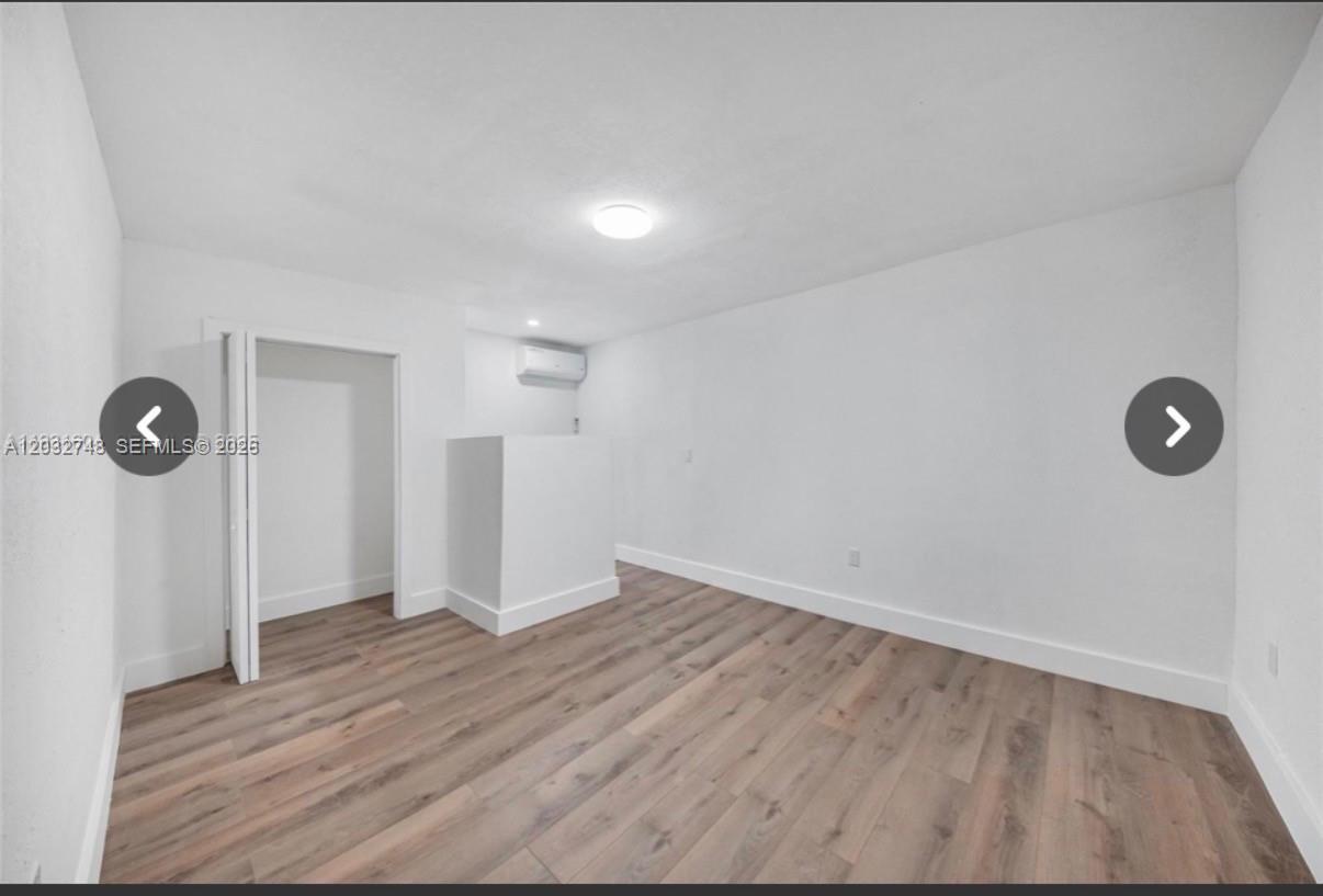 An empty room with white walls, light wood-look flooring, and a small wall protrusion — 6915 NW 4th Ct # 6915, Miami FL 33150, MIAMI, FL