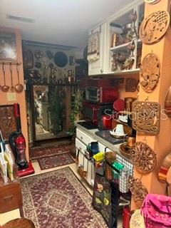 A kitchen features wooden cabinets, a microwave, and decorative wall hangings above a patterned rug — 115 OYSTER BAY CIRCLE UNIT 360, ALTAMONTE SPRINGS, FL