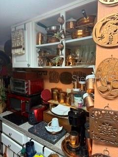 A kitchen features white cabinets, copper cookware, and a red toaster oven on the counter — 115 OYSTER BAY CIRCLE UNIT 360, ALTAMONTE SPRINGS, FL