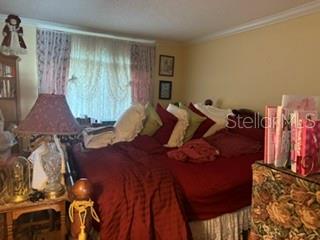 A bedroom features a bed with red bedding, a lamp, and a window with curtains — 115 OYSTER BAY CIRCLE UNIT 360, ALTAMONTE SPRINGS, FL