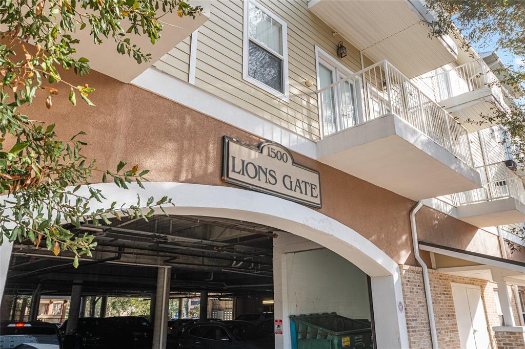 The exterior of a multi-story apartment building features a covered parking area and balconies — 1500 NW 4TH AVENUE UNIT 203, GAINESVILLE, FL