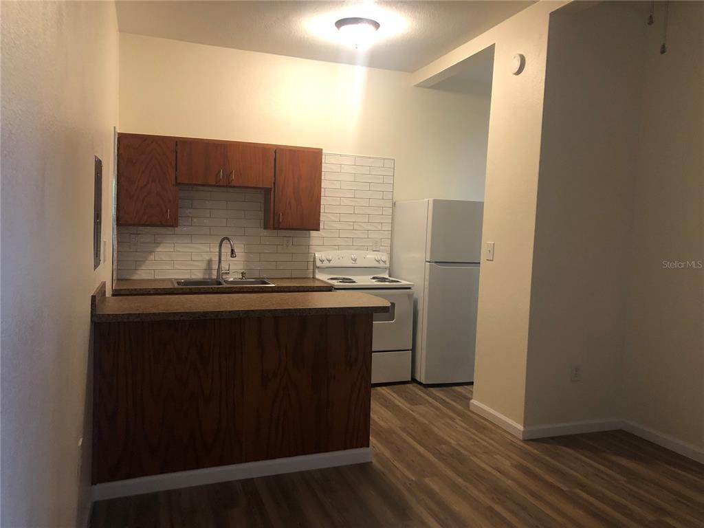 A kitchen features wood cabinets, a white subway tile backsplash, and a white stove — 161 W 2ND AVENUE, PIERSON, FL