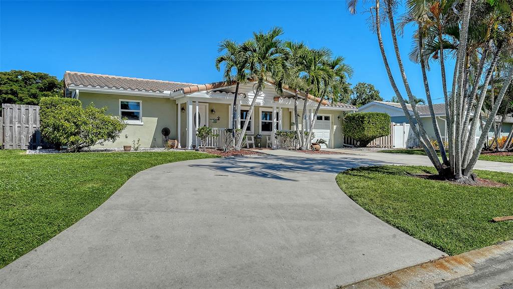 A single-story house with a concrete driveway, palm trees, and a light-colored exterior — 3507 PINECREST STREET, SARASOTA, FL