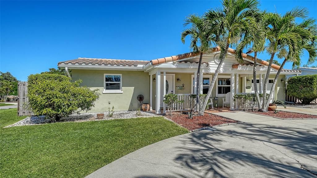 A single-story house with a light green exterior, tile roof, and palm trees in front — 3507 PINECREST STREET, SARASOTA, FL