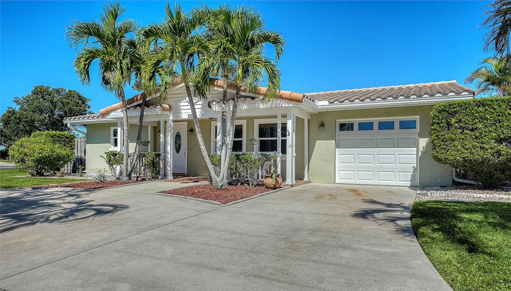 A single-story house with a concrete driveway, palm trees, and a white garage door — 3507 PINECREST STREET, SARASOTA, FL