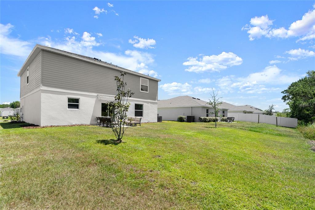 The exterior view shows the back of a two-story house with a grassy yard — 2516 HOPTREE LANE, EDGEWATER, FL