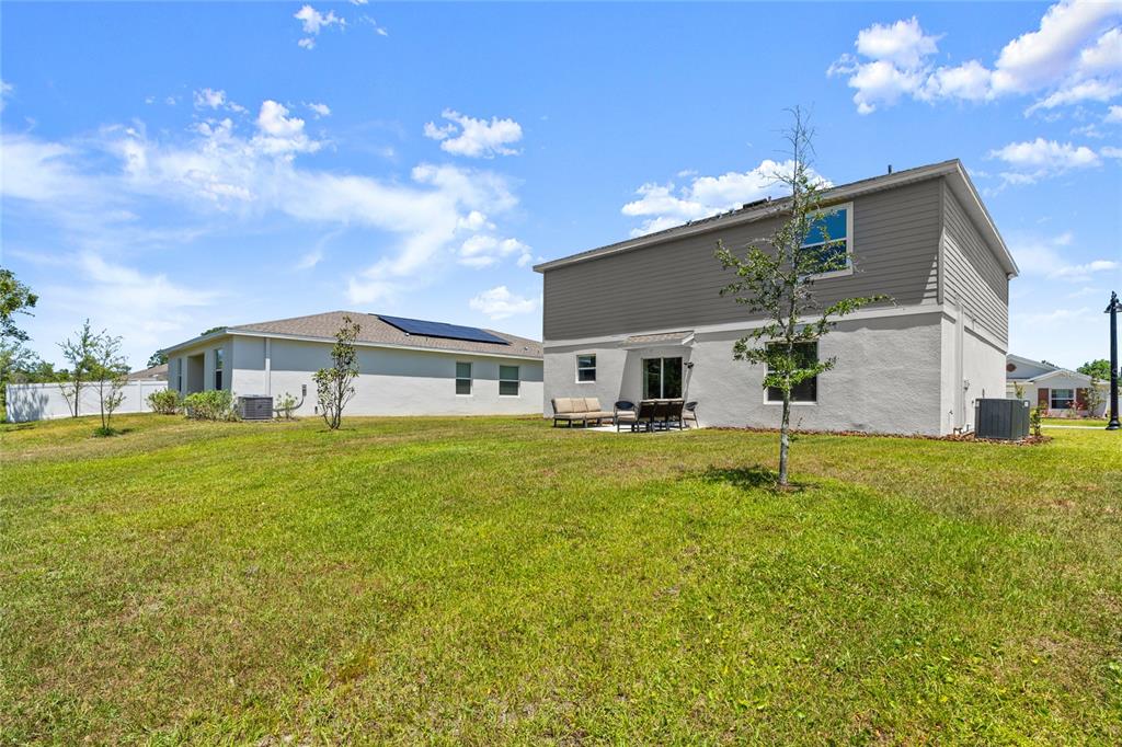 The exterior of a two-story house features a gray upper level and a white lower level — 2516 HOPTREE LANE, EDGEWATER, FL