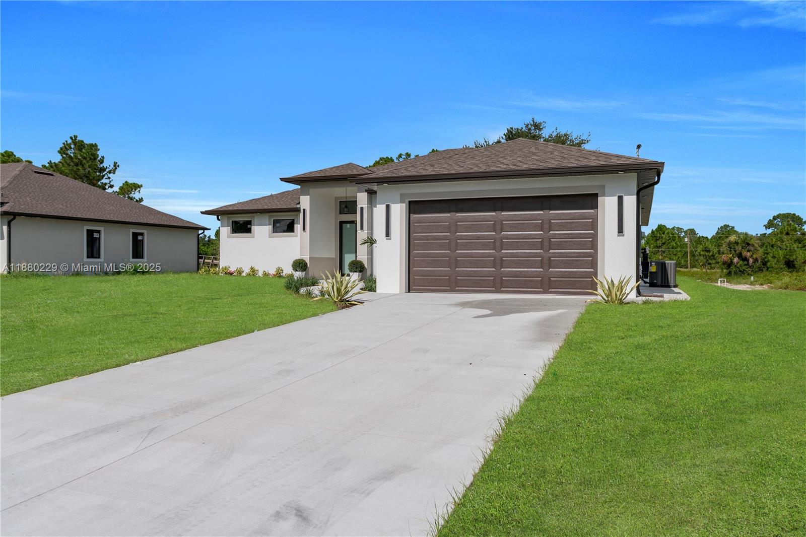 A single-story house with a brown roof, white stucco exterior, and a two-car garage — 1913 IRVING AVE, Lehigh Acres FL 33972, LEHIGH ACRES, FL