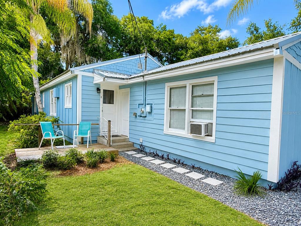 A light blue house with white trim, a wooden deck, and a gravel walkway — 112 S DIXIE AVENUE UNIT 2, FRUITLAND PARK, FL