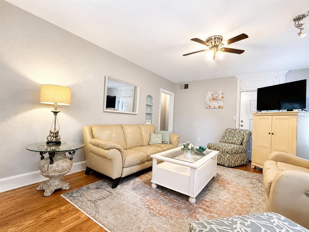 A living room features a beige sofa, a white coffee table, and a patterned armchair — 112 S DIXIE AVENUE UNIT 2, FRUITLAND PARK, FL