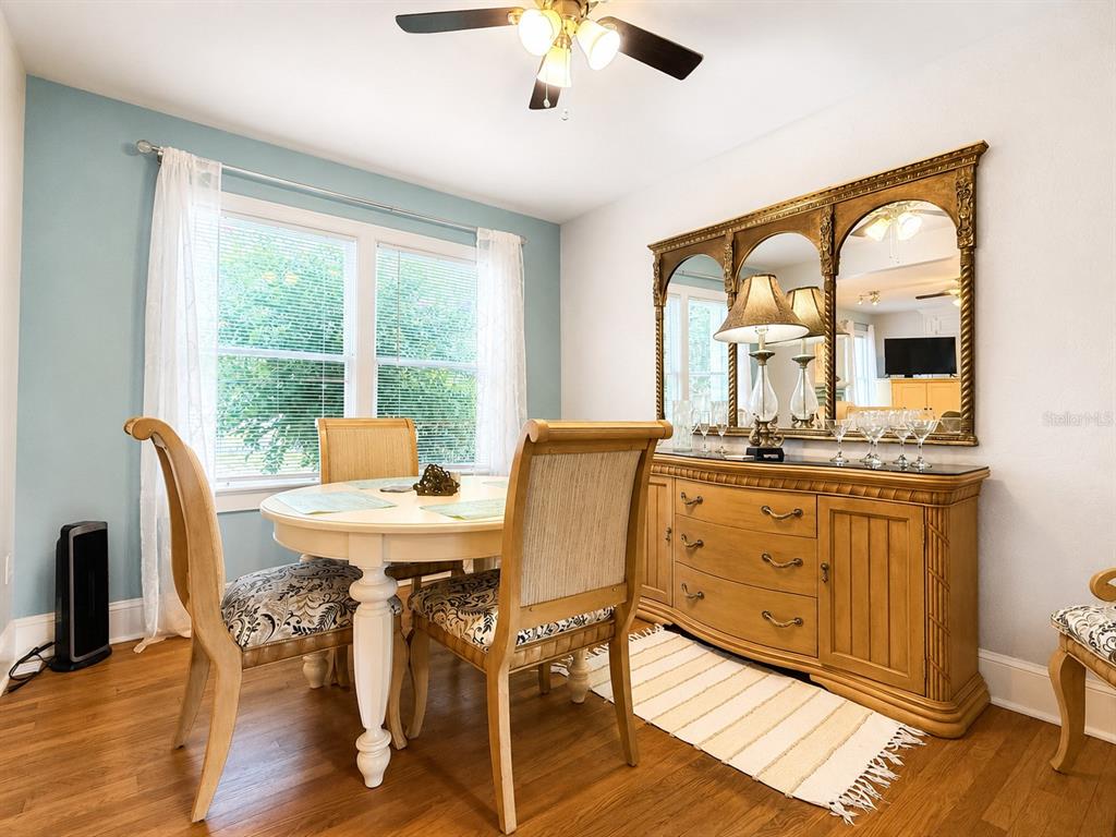 A dining room features a round table, chairs, a wooden sideboard, and a large mirror — 112 S DIXIE AVENUE UNIT 2, FRUITLAND PARK, FL