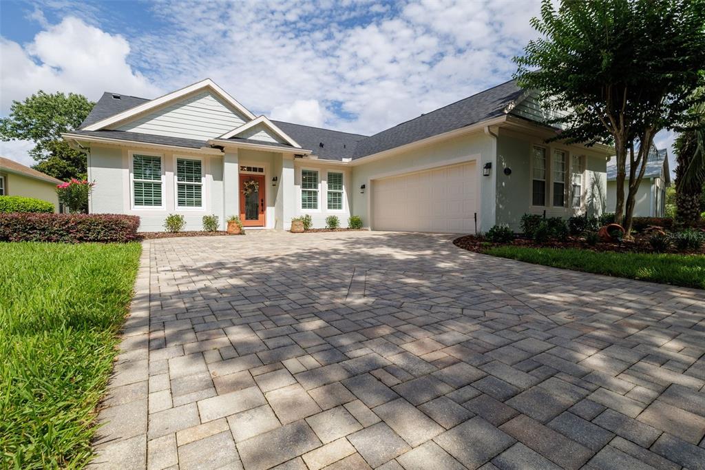 A single-story house with light green siding, a paved driveway, and a two-car garage — 309 BELLINGRATH TERRACE, DELAND, FL