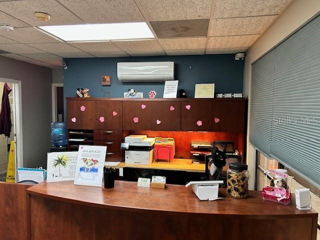 A reception desk with wooden cabinets and office equipment sits in a pet-themed office space — 3468 E SEMORAN BOULEVARD, APOPKA, FL