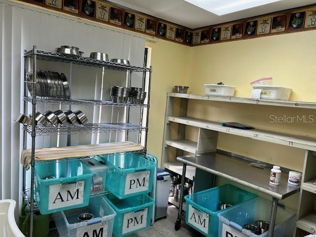 A utility room features metal shelving units, plastic storage bins labeled AM and PM, and wallpaper — 3468 E SEMORAN BOULEVARD, APOPKA, FL
