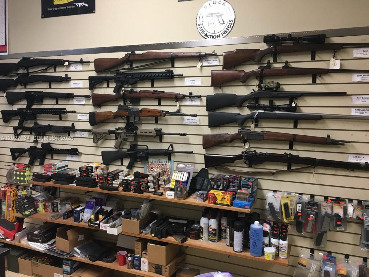 A retail store wall displays various rifles and shelves stocked with ammunition and accessories — 2005 W 62nd St, Hialeah FL 33016, HIALEAH, FL