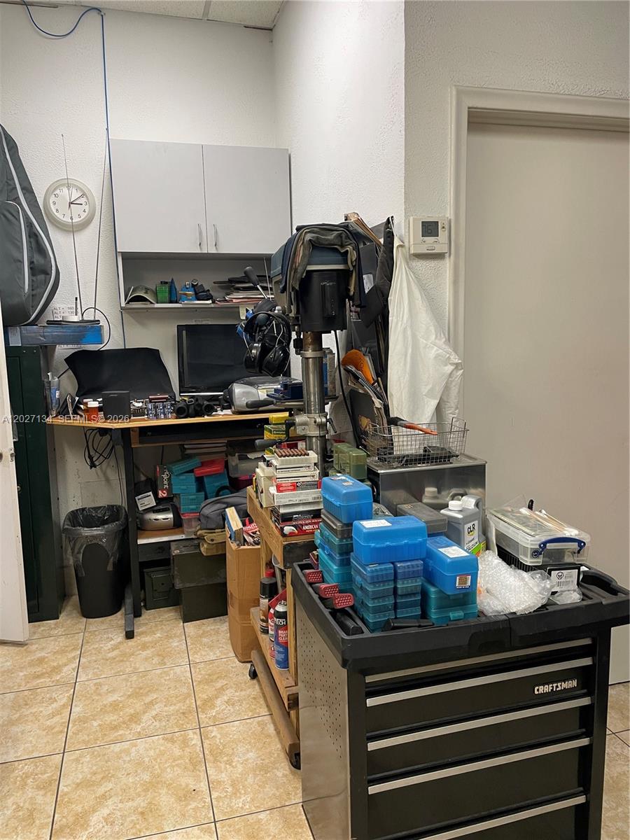 A cluttered workshop or utility room features a workbench, a drill press, and a Craftsman cart — 2005 W 62nd St, Hialeah FL 33016, HIALEAH, FL