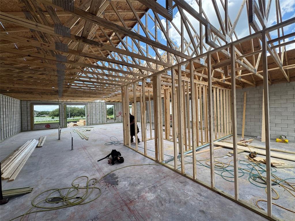 Interior view of a house under construction with concrete block walls and exposed wood trusses — 30241 RUSTIC MILL STREET, MOUNT DORA, FL