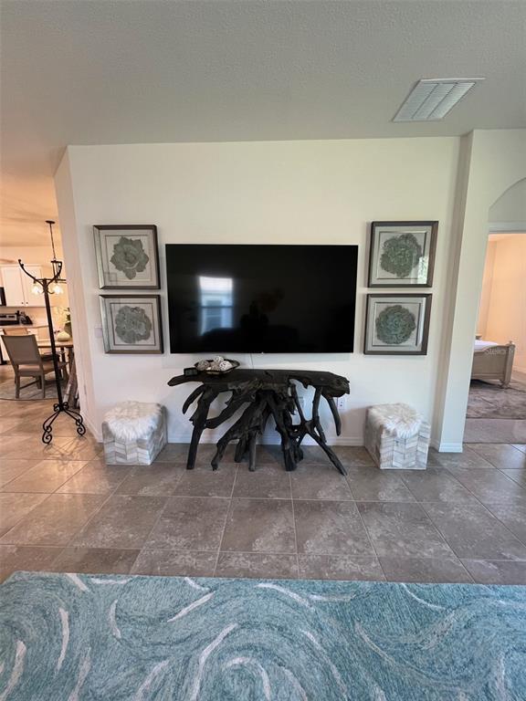 A living room wall features a mounted television above a dark, organic-shaped wooden console table — 5375 NW 48TH PLACE, OCALA, FL