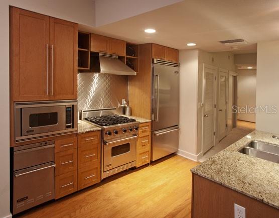 A kitchen with wood cabinets, stainless steel appliances, and granite countertops — 1208 E KENNEDY BOULEVARD UNIT 1120, TAMPA, FL