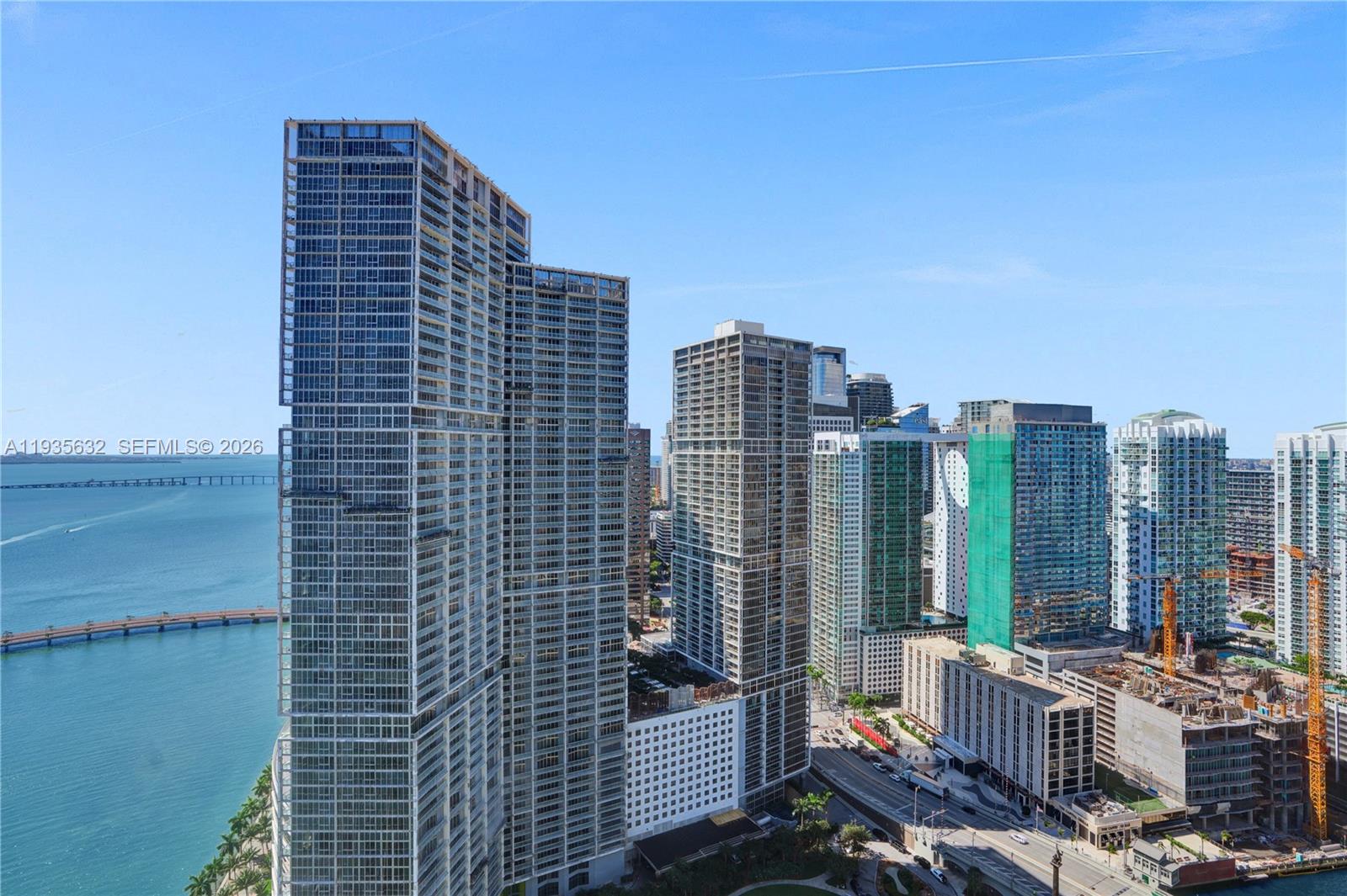 An aerial view shows several modern high-rise glass skyscrapers situated along a waterfront — 300 Biscayne Blvd Way # 3704C, Miami FL 33131, MIAMI, FL