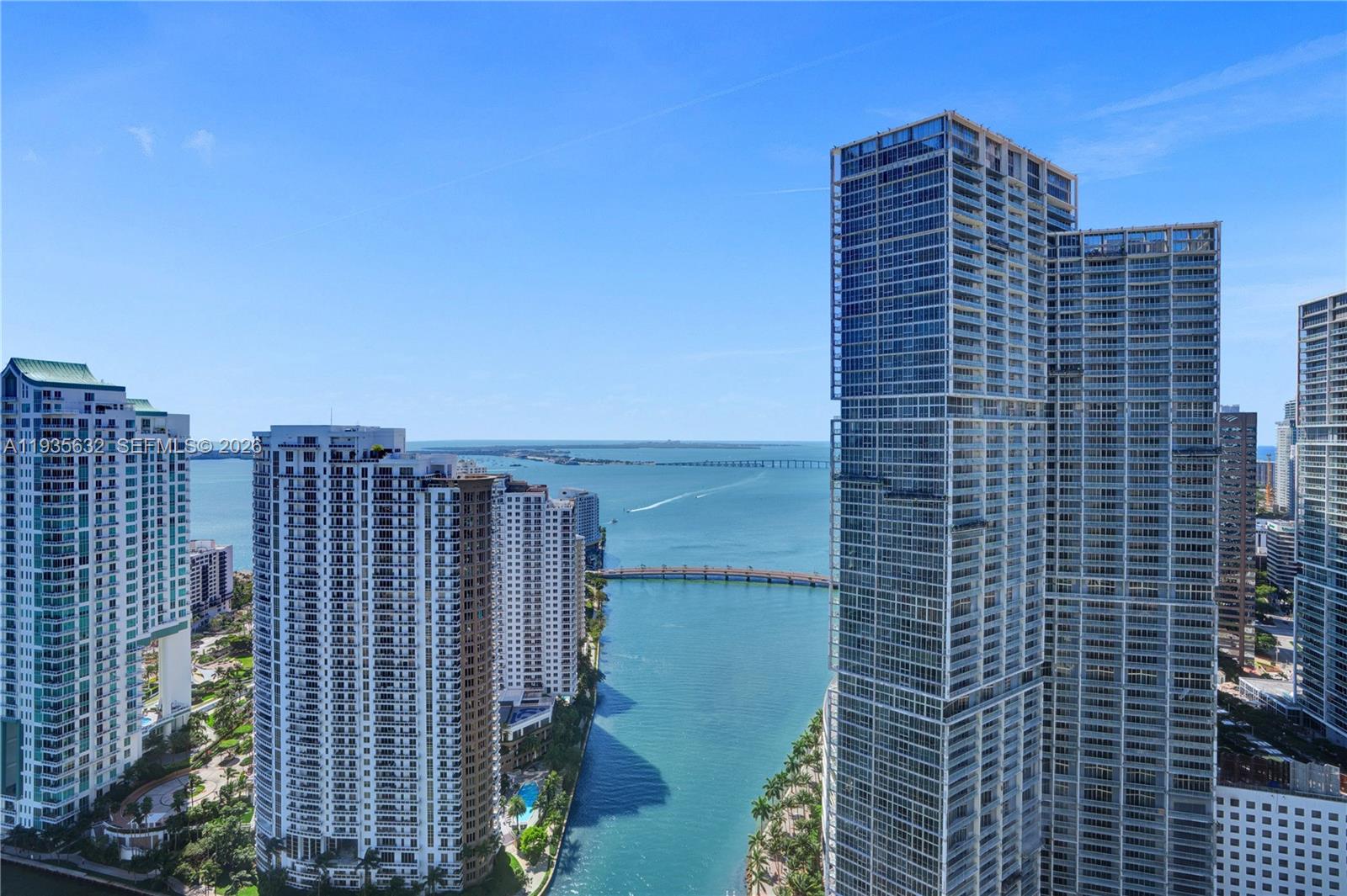 An elevated exterior view shows multiple high-rise apartment buildings overlooking a bay and bridge — 300 Biscayne Blvd Way # 3704C, Miami FL 33131, MIAMI, FL