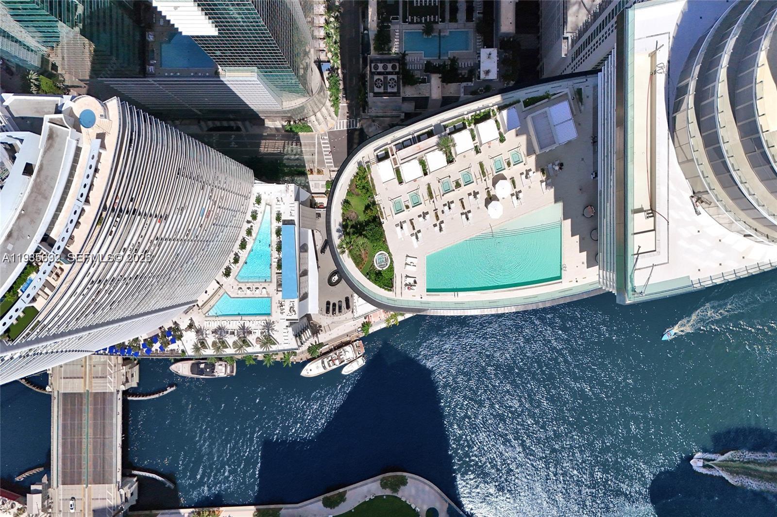 Aerial view of high-rise buildings with swimming pools and a boat docked in the water — 300 Biscayne Blvd Way # 3704C, Miami FL 33131, MIAMI, FL