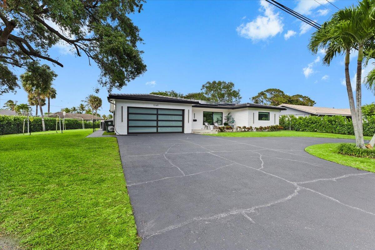 A single-story white house with a dark roof and a large asphalt driveway — 1049 W Palmetto Park Road, Boca Raton FL 33486, BOCA RATON, FL