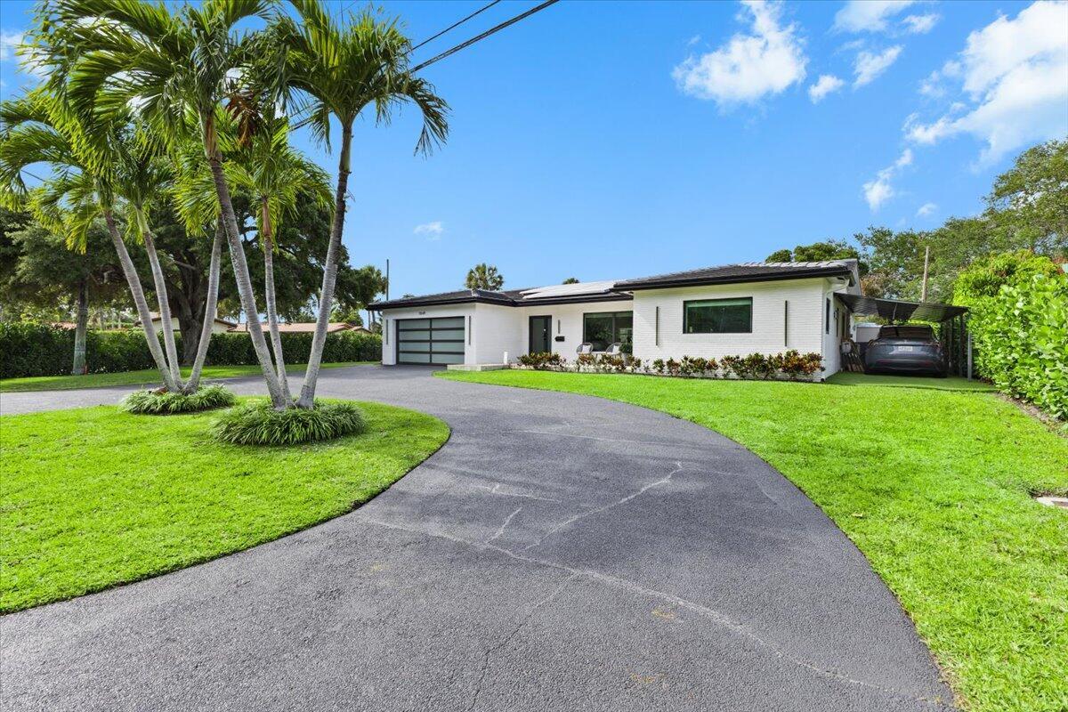 A white single-story house with a dark roof, attached garage, and a curved asphalt driveway — 1049 W Palmetto Park Road, Boca Raton FL 33486, BOCA RATON, FL