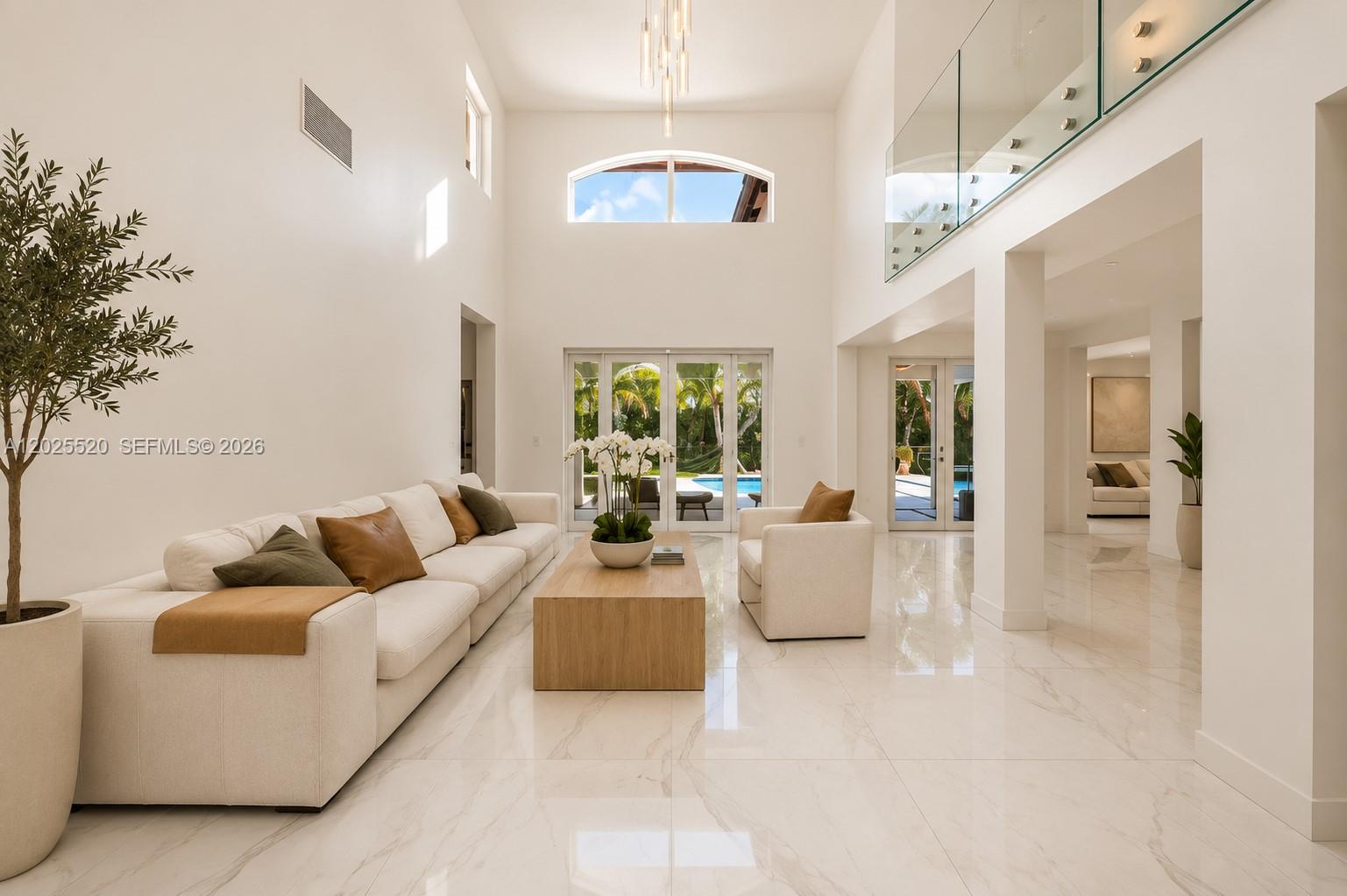 A bright, high-ceilinged living room features white walls, marble floors, and glass balcony railings — 15721 NW 79th Ct, Miami Lakes FL 33016, MIAMI LAKES, FL